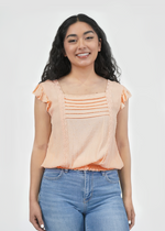 Front of model wearing Amy ruffle sleeve top in peach parfait