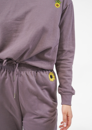 
                  
                    Close up of embroidered sunflower on joggers
                  
                