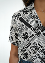 Close up front view of model wearing sydney shirt with newspaper print