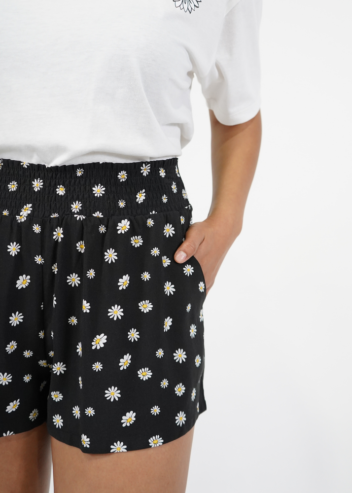 
                  
                    Close up of model wearing Malibu shorts in black daisy print
                  
                