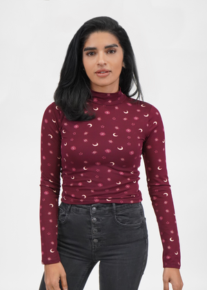 
                  
                    Model wearing Celine cropped top with crescent moons and stars print on a maroon color knit mock neck top
                  
                