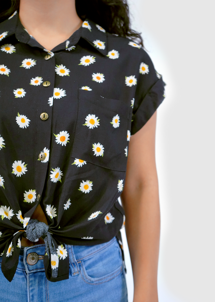 
                  
                    Close up of model wearing Malibu Dolman in black daisy print
                  
                