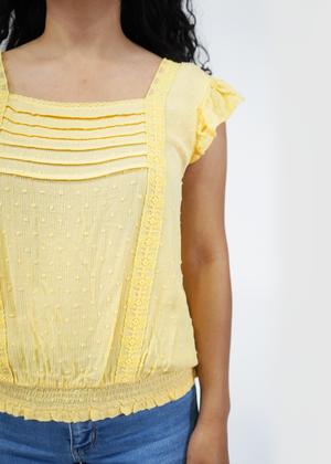 
                  
                    Close up of model wearing Amy ruffle sleeve smocked top in luna yellow
                  
                