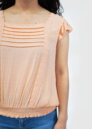 
                  
                    Close up of model wearing Amy ruffle sleeve top in peach parfait
                  
                