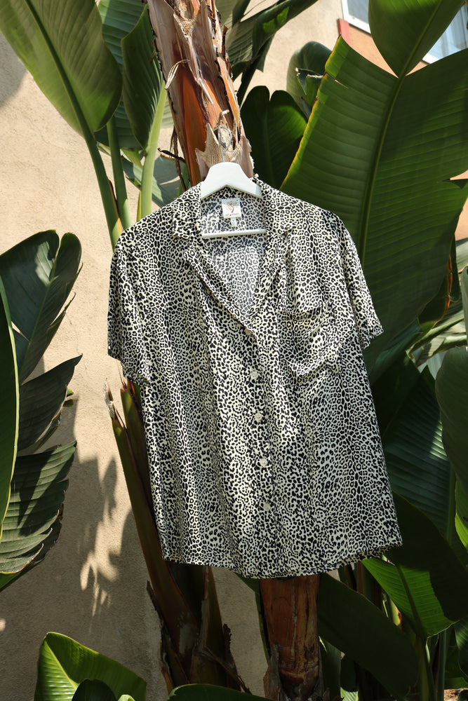 
                  
                    Product shot of leopard print Sydney shirt in front of palm trees
                  
                